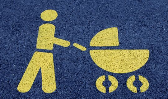 a yellow man pushing a yellow stroller, spray painted onto a blue road surface